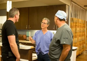 Dr. Rodrigue and surgical team discussing treatment with patient at front desk